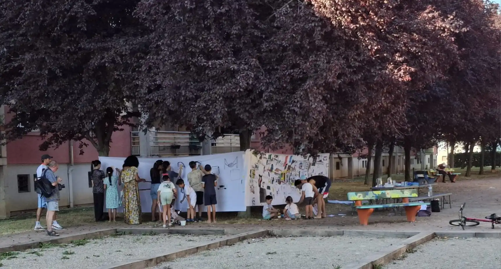 Enfants et habitants devant les dessins réalisés lors des ateliers créatifs de Quartier d'été, au quartier ICF de Bischheim